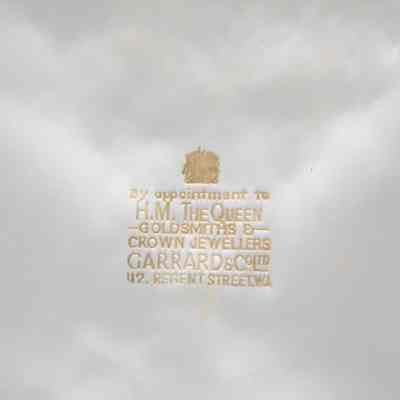 Label inside box: A gold label inside the white box, stating, "By appointment to H.M. The Queen; Goldsmiths & Crown Jewellers; Garrad & Co. Ltd. 112 Regent Street. WA."
