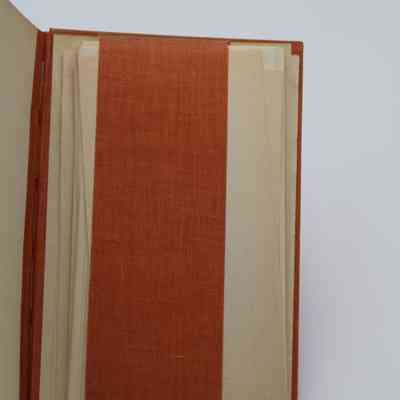 Inside back cover of "The Arab of the Desert": The back cover includes a fabric strip for holding paper, many papers are tucked in.