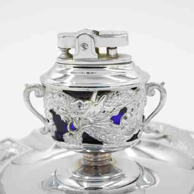 Silver and cobalt glass lighter from Persia.: Up close image of the silver and blue cobalt glass ashtray and lighter. Both are decorated with dragon motifs.