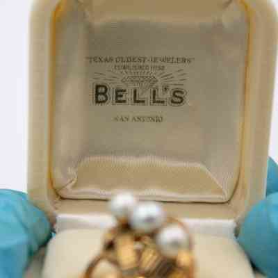 Inside the lid of the white case.: Image of the white case stamped with "'TEXAS OLDEST JEWELERS' ESTABLISHED 1852 BELL'S SAN ANTONIO" in black ink on the inside of the lid.