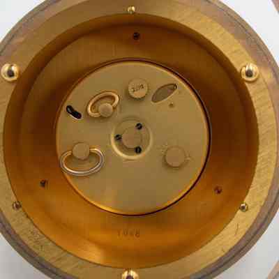 Back of the Luxor 8-Day World Time Desk Clock.: Up close image of the back of the Luxor clock. There are dials for setting the alarm and date and rotating the arms. There is also an etched number, "1048."