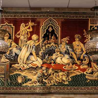 Hanging lanterns: A pair of ornate brass hanging lanterns with intricate flower designs illuminate a decorative tapestry.