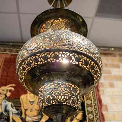 Hanging lantern: The image shows a brass hanging lantern with intricate floral design, casting a warm glow.