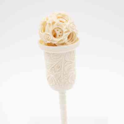 Carved ivory Chinese puzzle ball with pedestal.: Image of the carved ivory Chinese puzzle ball with pedestal. It is engraved with a floral rose design.