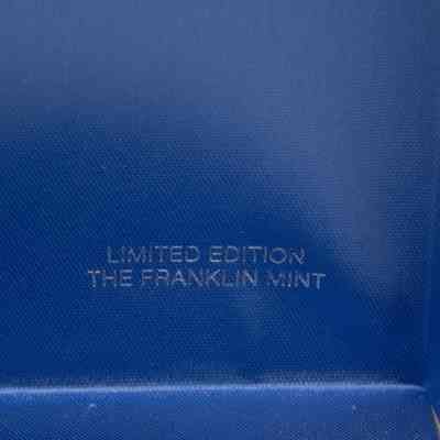 Image of the official stamp on the inside of the box.: Close up image of silver writing on a blue satin background, it reads "LIMITED EDITION" on the top line and "THE FRANKLIN MINT" on the bottom.