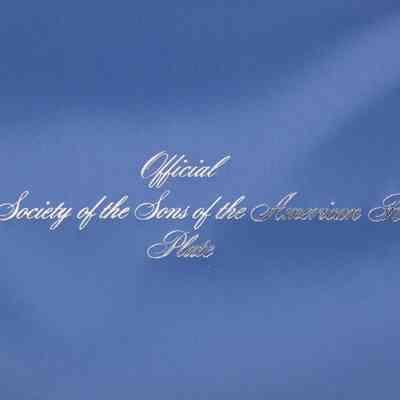 Image of the official stamp on the inside of the box.: Image of the silver writing on the inside of the blue satin lid, reads "Official National Society of the Sons of the American Revolution Plate."