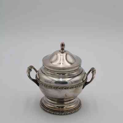 Sugar bowl: The silver sugar bowl features intricate handles and a decorative lid.