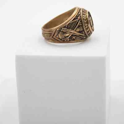 Side of L.T. Jordan's 1929 class ring from Texas A&M University.: Image of the right side of L.T.'s class ring from Texas A&M. There is a cannon, rifle, and saber embossed on the side. Behind the weapons is both the Texas and United States flags.