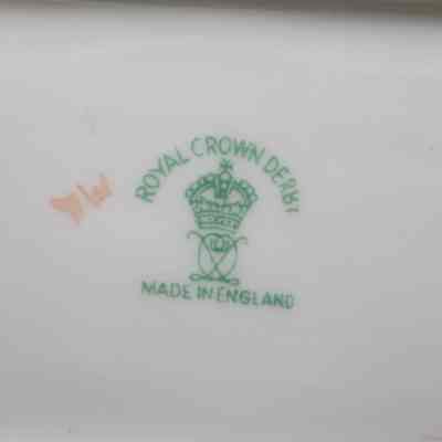 Bottom of one of the Royal Crown Derby rectangular ashtrays.: Up close image of the bottom of the rectangular ashtray. There is a green stamped maker's mark that reads "ROYAL CROWN DERBY MADE IN ENGLAND" with a crown in the middle.