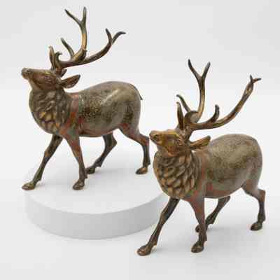 Two brass reindeer: Two brass, male reindeer, all identical. They have etchings and orange enamel detail.