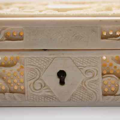Lock on the carved ivory dragon box from India.: Up close image of the key hole in the center of the front of the box.