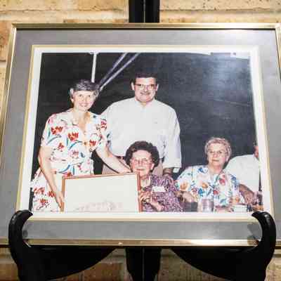 Photograph of Jessie Jordan Receiving Print of TAMU President's Home on Black Stand