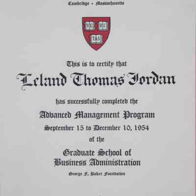 Harvard Advanced Management Program 26th Session Certificate: Close-up image of the certificate in its glass case. The Assistant Dean who taught the course and the Dean of the School of Business Administration at Harvard have signed their names. The Harvard logo is featured prominently.