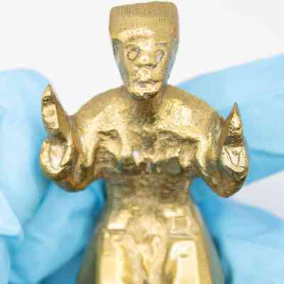 Close-up of handle: A close-up on the man's face and hands. His hands are sharp, shaped roughly into a triangle. His facial features include two ellipses, a wide nose, and an open mouth.