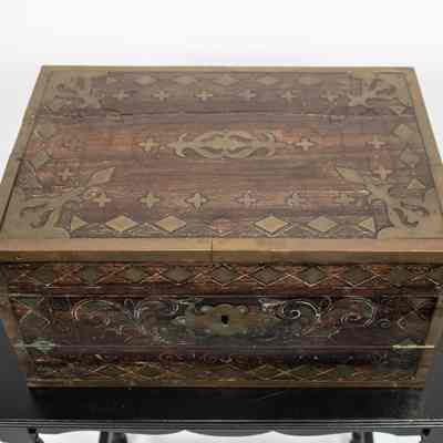 Top view of desk: The image shows a shut folding wooden desk from Venezuela, made of portable ebony wood, featuring intricate decorative inlays.