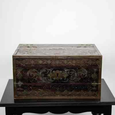 Front view of desk: The image shows a closed, decorative, portable wooden writing desk from Venezuela, featuring intricate patterns.