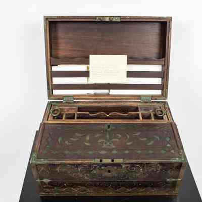 Inside of desk: The image shows an intricately carved, portable ebony writing desk with various compartments and a hinged lid.