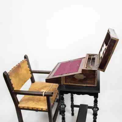 Desk, table, and chair: The image shows an open folding wooden desk with elegant carved legs beside a studded leather chair.