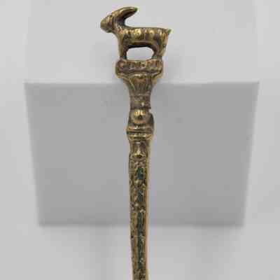 Capri Spoon Handle: Close up image of the spoon's handle. The handle is engraved with designs that travel to the top of the handle, with the "CAPRI" engravement finishing it. On the top of the handle stands a goat that is facing to the left.