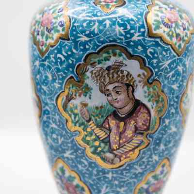 Blue vase with woman: The small blue enameled vase features intricate designs with people and birds, surrounded by floral and ornamental patterns.