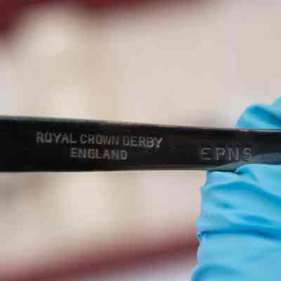 Engraving on the back of the silver Royal Crown Derby salad spoons.: Up close image of the stamped company name on the back of the silver salad spoons. Each spoon is engraved with "ROYAL CROWN DERBY ENGLAND" and the letters "EPNS."