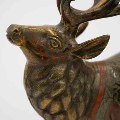 Reindeer neck and face: The reindeers face has open eyes with orange leaf and vine embellishments. Its neck has individual hairs carved into tufts of fur.