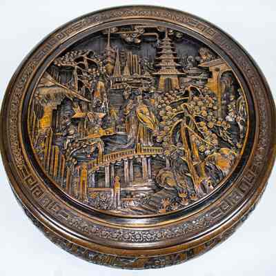 Top of round carved Hong Kong table: The round Hong Kong table displays intricate wood carvings beneath a transparent glass top.