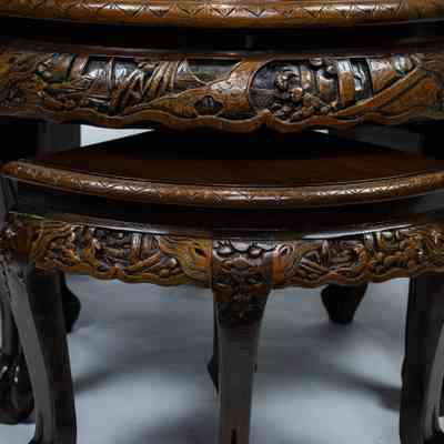 Side of round carved Hong Kong table and stools: The image shows a round, intricately carved Hong Kong table with a glass top on ornate legs.