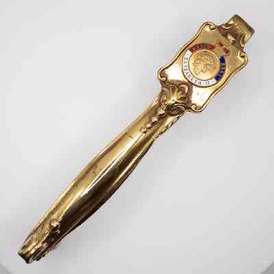 Gold Elizabeth II coronation nutcracker: The image features a gold souvenir nutcracker with decorative details, a crest, and engraved text commemorating Queen Elizabeth II.