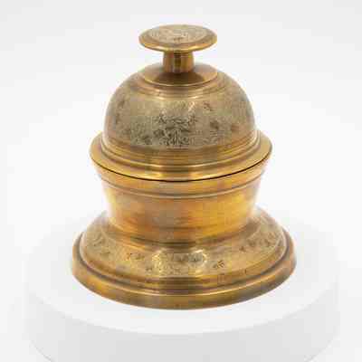 Meditation bell: A brass meditation bell features intricate leaf designs on its surface.