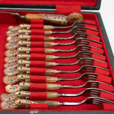 Forks in case: A set of seahorse-handled forks rests neatly in a red felt-lined case.