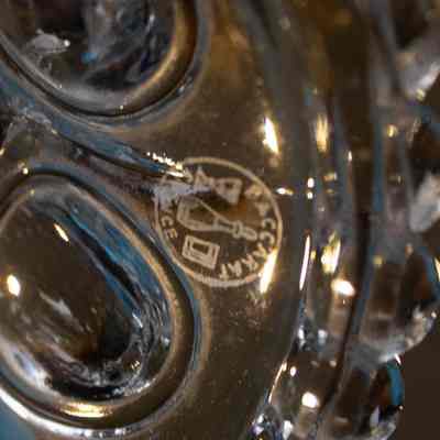 Baccarat logo in base of candelabras: The Baccarat logo is engraved on the candelabra's clear glass base.