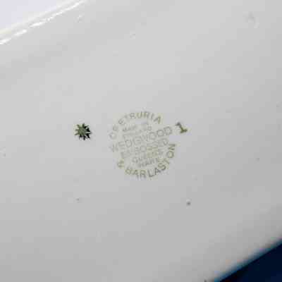 Bottom of cigarette box: The bottom of the cigarette box has "Wofetruria & Barlaston. Made in England; Wedgwood; Embossed queens ware."