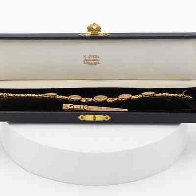 Bracelet in box with tie pin.: The bracelet lies in a black velvet box with a gold tie pin with “Gulf” in big letters. The box is labeled “K. UYEDA jeweller Imperial Hotel Tokyo.”