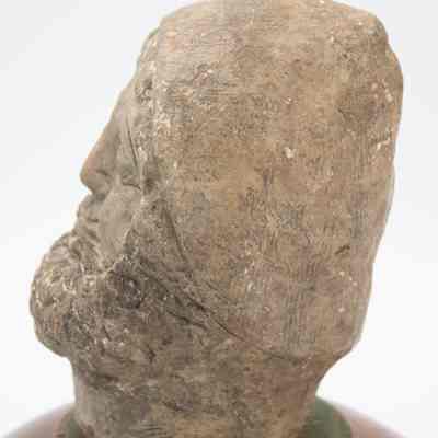 Side profile of Roman head: His side profile has very little detail. His hat is smooth and his beard is visible.