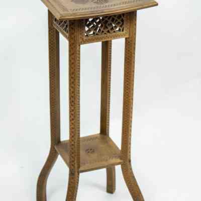 Tall table: A tall, intricately carved wooden table with a patterned top and four curved legs.
