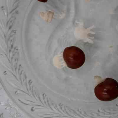 Seven lucky red seeds topped with miniature carved ivory elephants resting on a hexagonal crystal dish.: Up close image of the seven lucky red seeds topped with miniature carved ivory elephants resting on a hexagonal crystal dish. One of the small elephants has been detached and there is a small ivory elephant lying in the middle.
