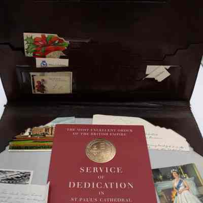 Items inside desk mat: Different photos are inside the mat, including photos of Queen Elizabeth II, and a Service of Dedication program.