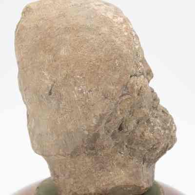 Side profile of Roman head: His side profile has very little detail. His hat is smooth and his beard is visible.
