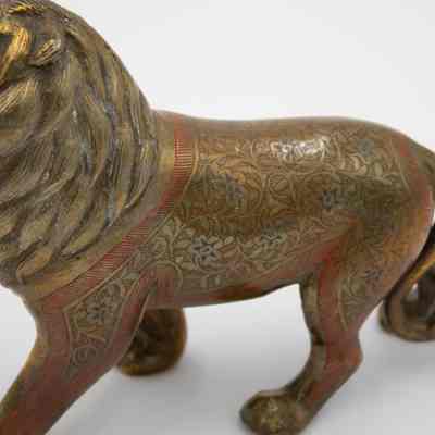 Lion body design close-up: A brass male lion with red and blue enamel flowers and patterns along the side of his body. The inside of his mouth is red.