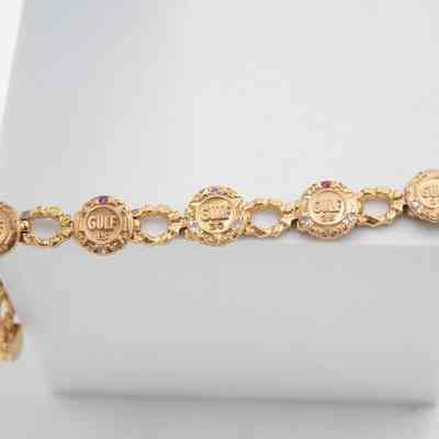 14k gold Gulf Oil bracelet.: The bracelet has 5 big circular charms connected by big circular links. Each charm has. 5 year increments from 10 through 30 celebrating years in the company. Each charm has various gems corresponding to years in the company.