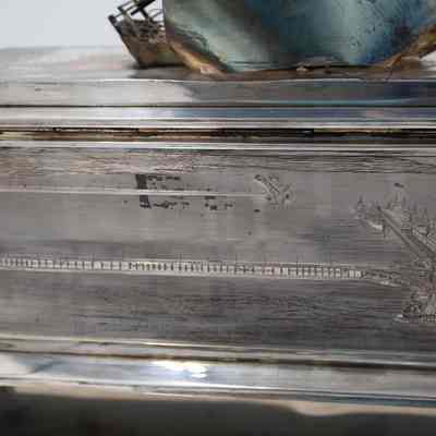 Back of the silver casket humidor.: Image of the engraving on the back of the silver casket humidor depicting a sea oil rig.