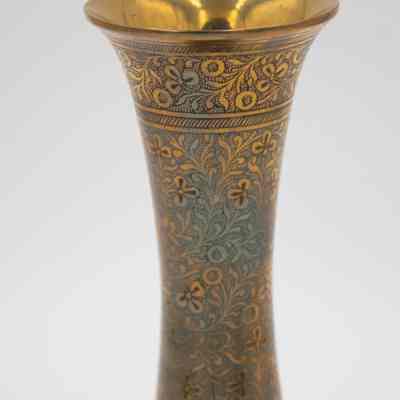 Skinny brass vase: The image shows a single, slender, brass vase adorned with intricate blue and red floral motifs.