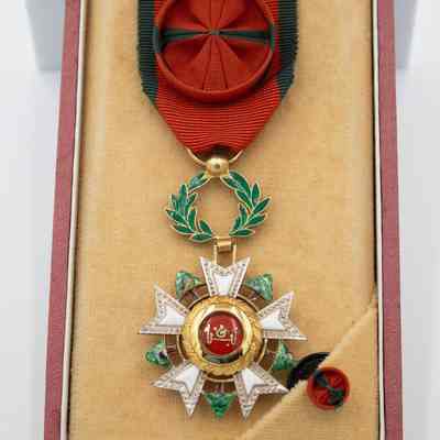 Lebanon National Order of the Cedar Medal: A medal with Arabic script and olive leaf enamel detail, affixed to a red ribbon with a circle pin indicating "Officer Level."