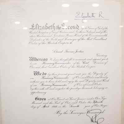 Certificate for LTJ Honorary Commander of the Order of the British Empire: The image shows a framed certificate granting LTJ the Honorary Commander of the British Empire title.