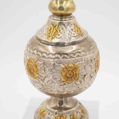 Body of the rose water sprinkler given to Mrs. Jessie Jordan by Mrs. Al-Ghanim.: Up close image of the body of the engraved silver rose water sprinkler decorated with yellow gold roses and leaves.