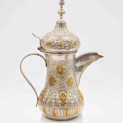 Coffee pot given to Mrs. Jessie Jordan by Mrs. Al-Ghanim.: Image of the engraved silver coffee pot decorated with yellow gold roses.