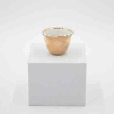 Small teacup given to Mrs. Jessie Jordan by Mrs. Al-Ghanim.: Image of a small porcelain handle-less teacup with gold layer on outside and at the top of the inside rim.