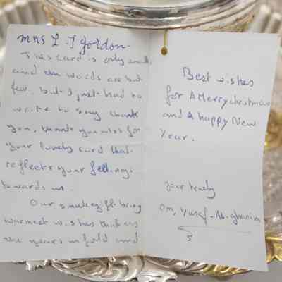 Inside of card found inside the incense burner given to Mrs. Jessie Jordan by Mrs. Al-Ghanim.: Image of white card with blue handwriting propped against the incense burner. The card reads "Mrs. L.T. Jordan, This card is only small and the words are but few, but I just had to write to say thank you. Thank you a-lot for your lovely card that reflects your feelings towards us. Our small gift bring warmest wishes that as the years unfold and Best wishes for a Merry Christmas and A happy New Year. Your truly Om, Yusef-Al-ghanim."