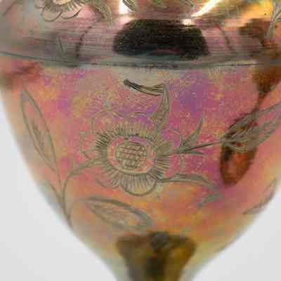 Flower engravings: A close-up of a scalloped brass vase shows intricate floral engravings.